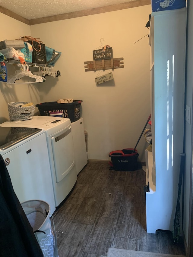 laundry area featuring washing machine and dryer, a textured ceiling, and dark wood-type flooring