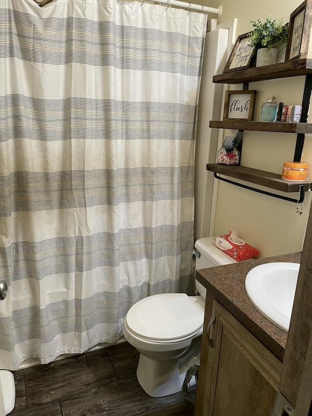 bathroom with toilet, vanity, a shower with shower curtain, and hardwood / wood-style floors