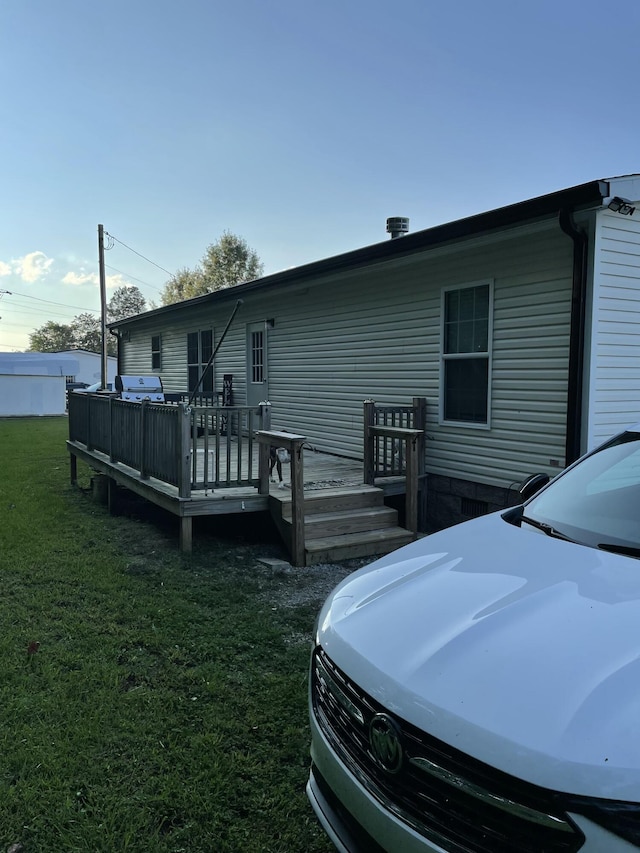 rear view of house with a yard and a wooden deck