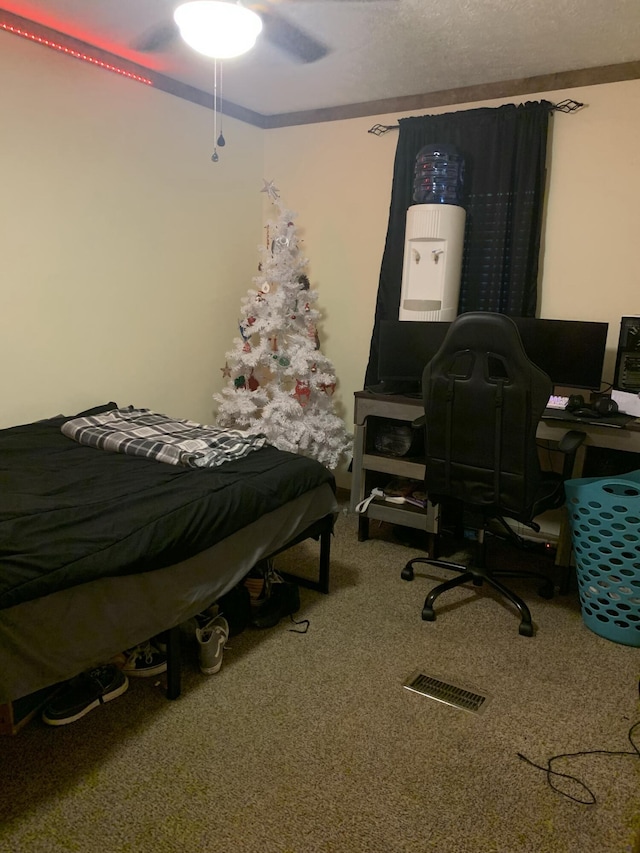 bedroom featuring carpet floors, ceiling fan, and a textured ceiling