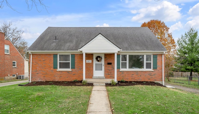 bungalow-style home with a front lawn and central air condition unit