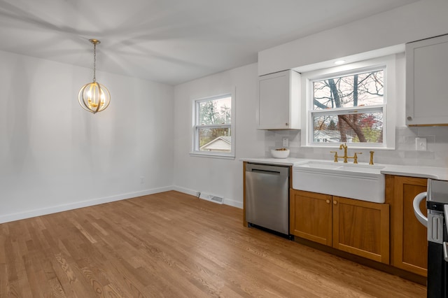 kitchen featuring dishwasher, sink, hanging light fixtures, decorative backsplash, and white cabinetry