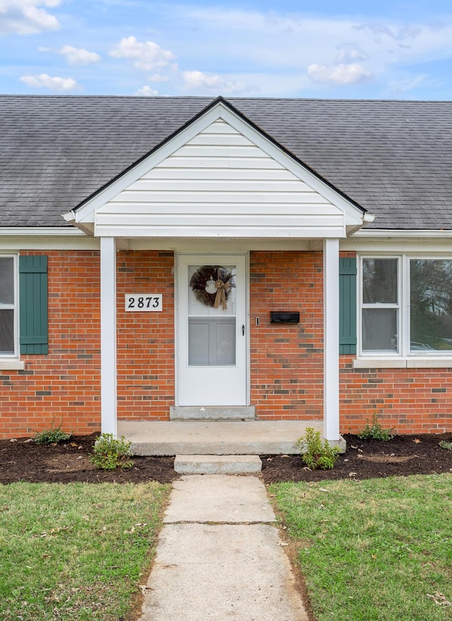 view of exterior entry featuring a yard