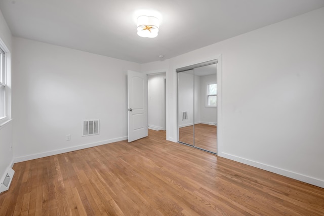 unfurnished bedroom featuring a closet and light wood-type flooring