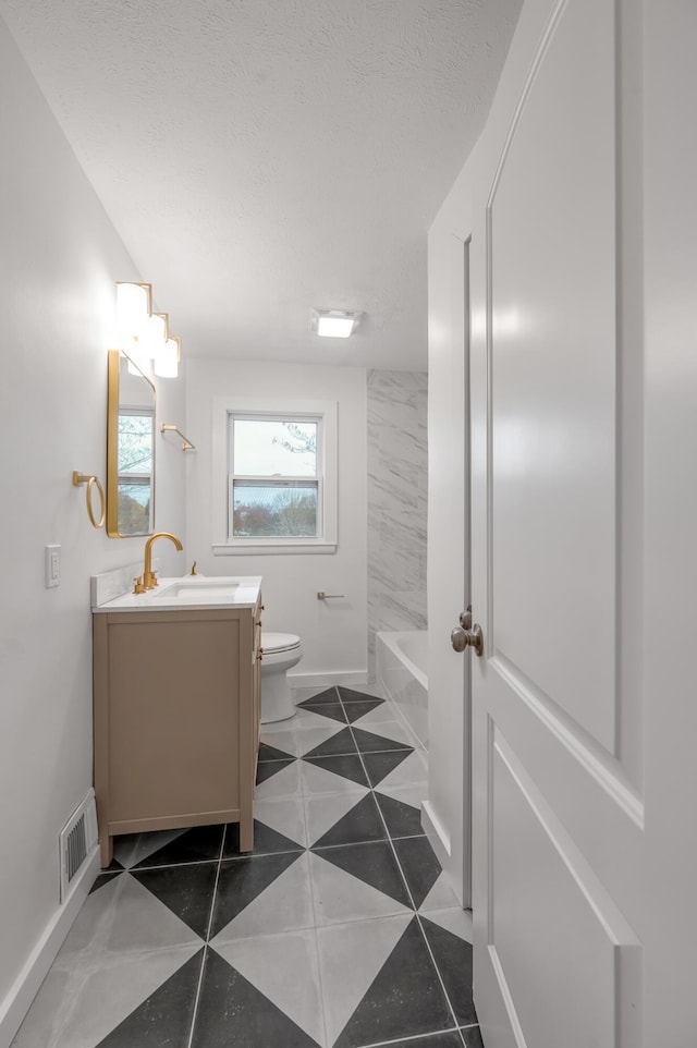 full bathroom with vanity, tile patterned floors, shower / washtub combination, toilet, and a textured ceiling