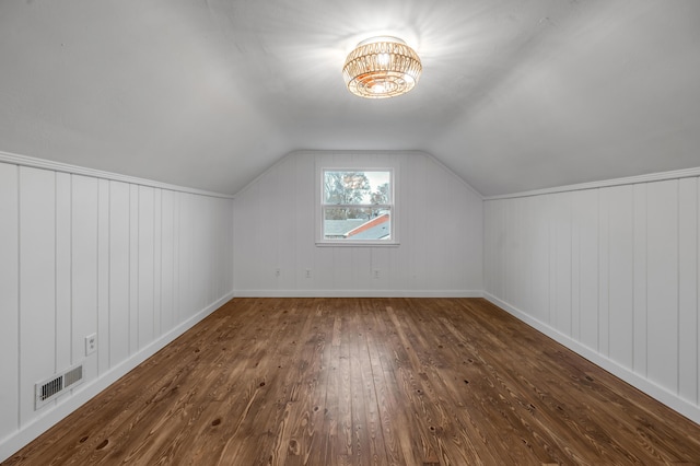 bonus room with dark hardwood / wood-style flooring and vaulted ceiling