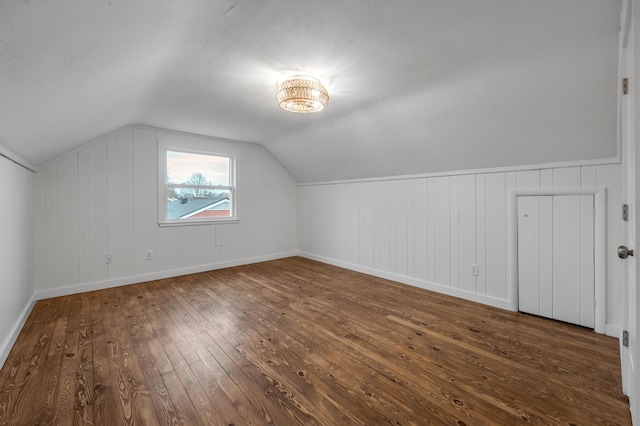 additional living space with dark hardwood / wood-style floors and vaulted ceiling