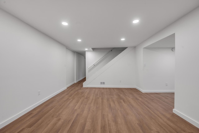 basement with light hardwood / wood-style flooring