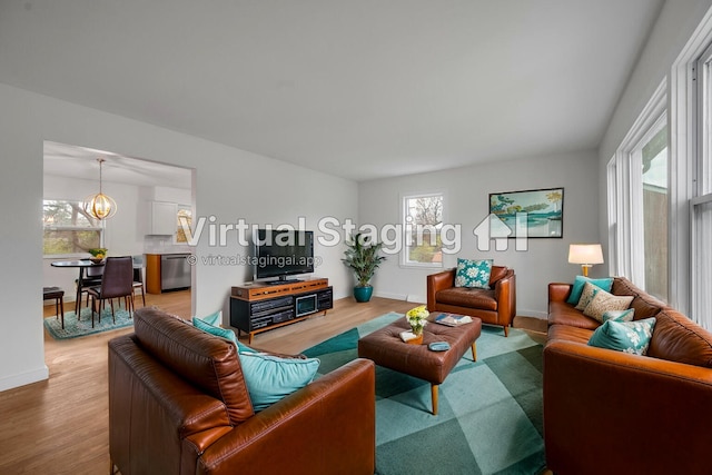 living room with hardwood / wood-style floors, an inviting chandelier, and a wealth of natural light