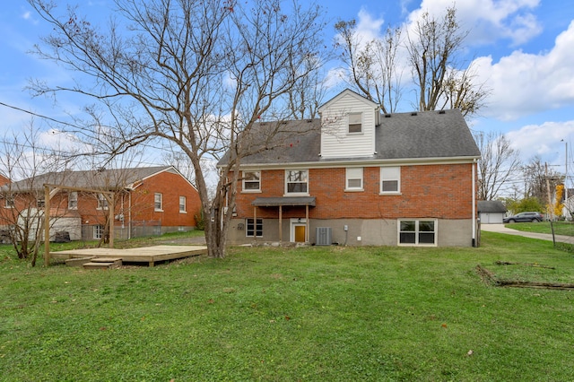 rear view of property featuring a lawn, central AC, and a wooden deck