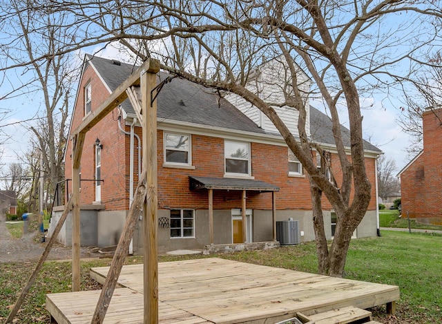 rear view of house with central air condition unit, a yard, and a deck