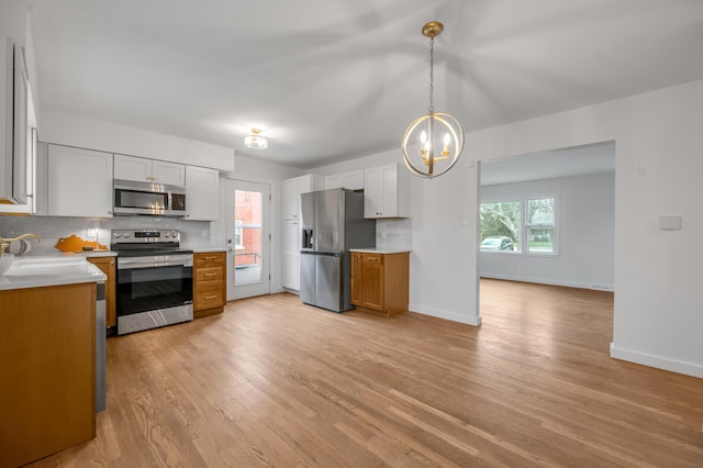 kitchen featuring white cabinets, stainless steel appliances, and tasteful backsplash