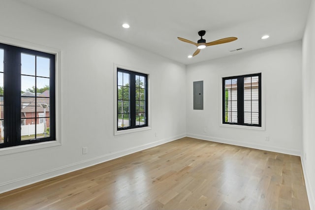 empty room featuring electric panel, light hardwood / wood-style flooring, and ceiling fan