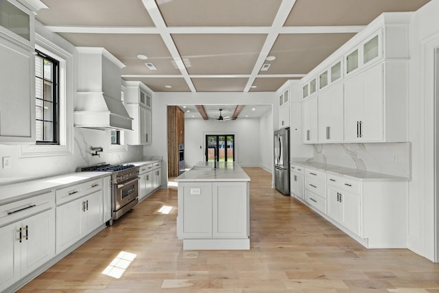 kitchen featuring coffered ceiling, stainless steel appliances, ceiling fan, white cabinetry, and a kitchen island