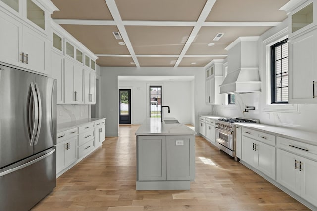 kitchen with stainless steel appliances, white cabinetry, coffered ceiling, and sink