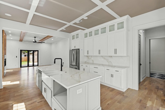 kitchen featuring white cabinets, a kitchen island with sink, and appliances with stainless steel finishes