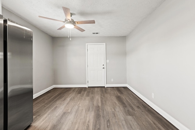 spare room with a textured ceiling, ceiling fan, and wood-type flooring