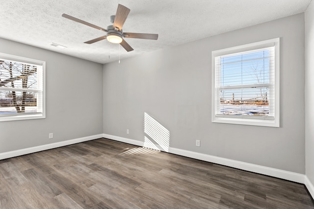 empty room with a textured ceiling, ceiling fan, and dark hardwood / wood-style floors