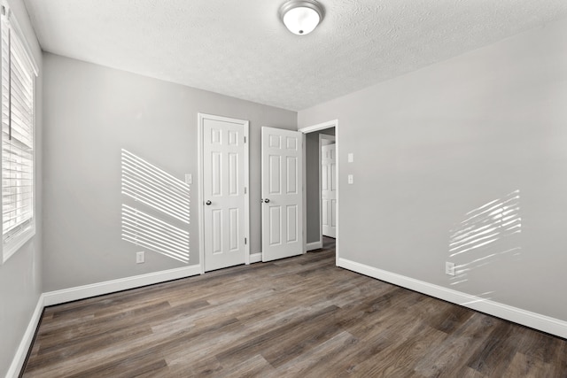 unfurnished room with a textured ceiling, hardwood / wood-style floors, and plenty of natural light