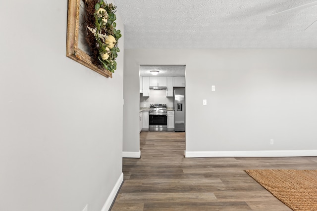 corridor featuring a textured ceiling and hardwood / wood-style floors