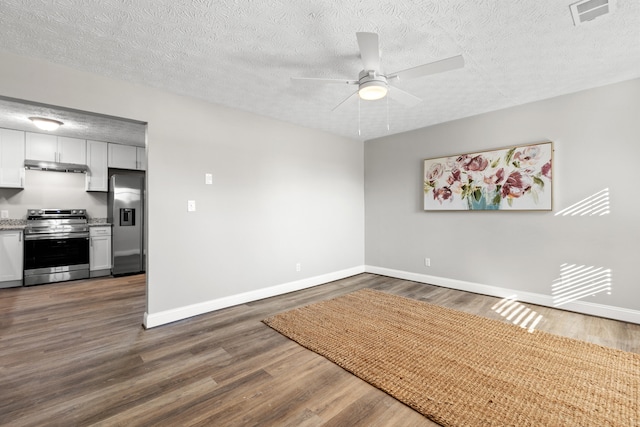 spare room featuring a textured ceiling, ceiling fan, and dark hardwood / wood-style flooring