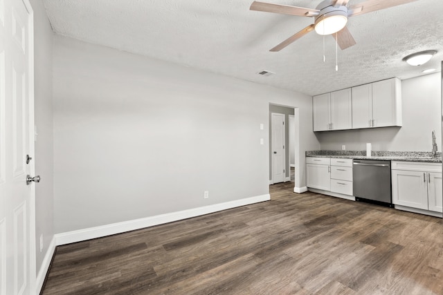 kitchen with dark hardwood / wood-style floors, a textured ceiling, white cabinetry, stainless steel dishwasher, and sink