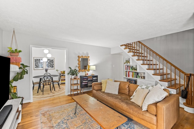 living room with a textured ceiling and light hardwood / wood-style flooring