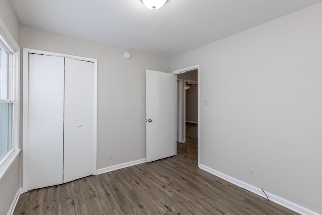 unfurnished bedroom with wood-type flooring and a closet