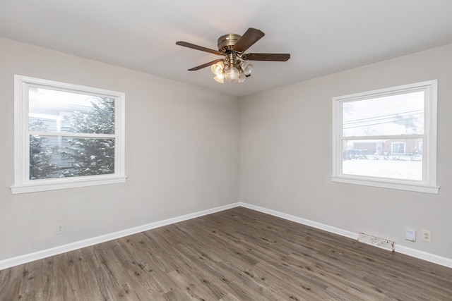 empty room with dark hardwood / wood-style floors and ceiling fan