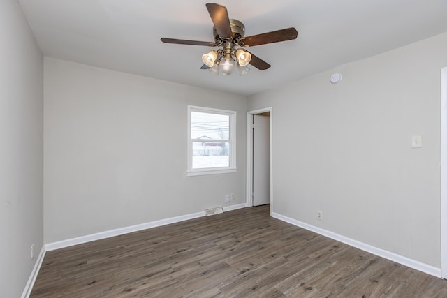 spare room with dark hardwood / wood-style flooring and ceiling fan