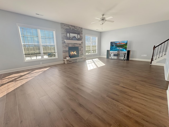 unfurnished living room with a fireplace, ceiling fan, and dark hardwood / wood-style flooring