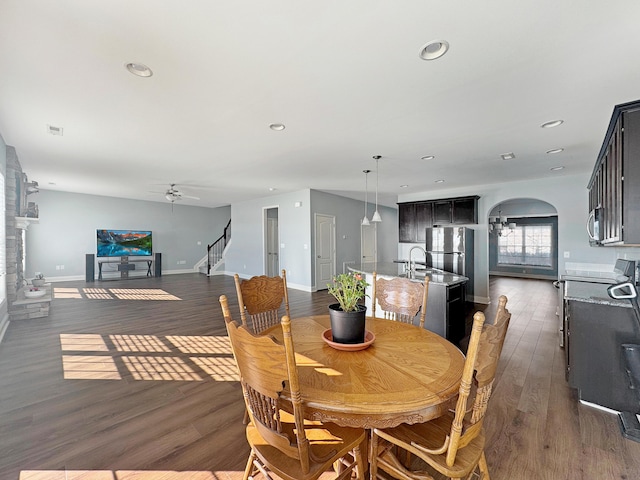 dining area featuring sink, ceiling fan, and dark wood-type flooring