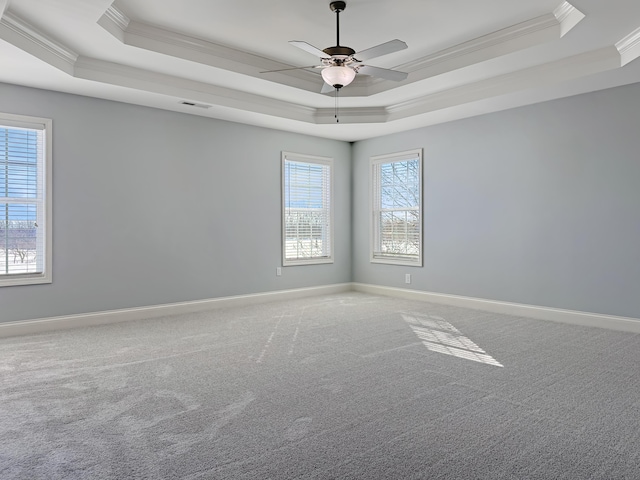 carpeted empty room featuring a tray ceiling, crown molding, and ceiling fan