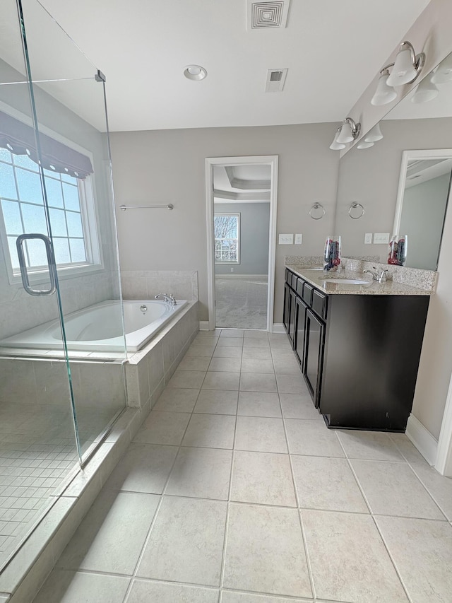 bathroom with tile patterned flooring, independent shower and bath, and vanity