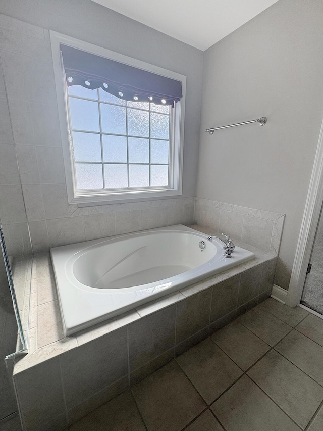 bathroom featuring tile patterned floors and a relaxing tiled tub