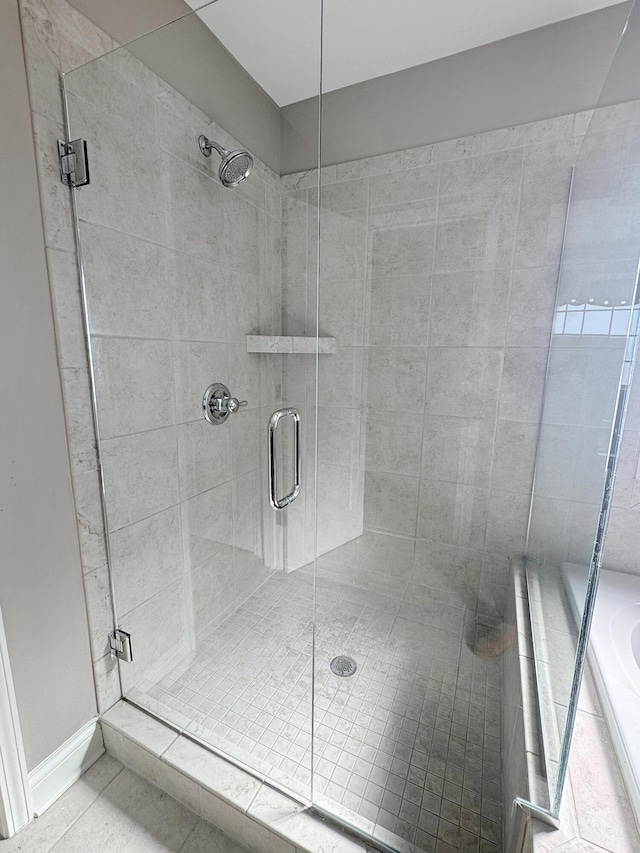 bathroom with tile patterned floors and shower with separate bathtub