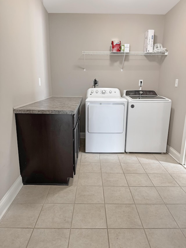 clothes washing area with washer and clothes dryer and light tile patterned floors