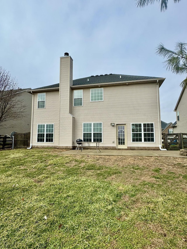 rear view of property with a yard and a patio area