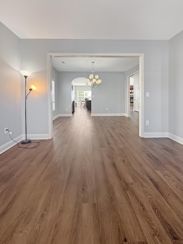 unfurnished living room featuring dark hardwood / wood-style flooring and a notable chandelier