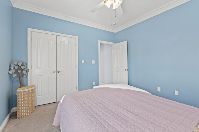 bedroom with crown molding, light colored carpet, ceiling fan, and a closet