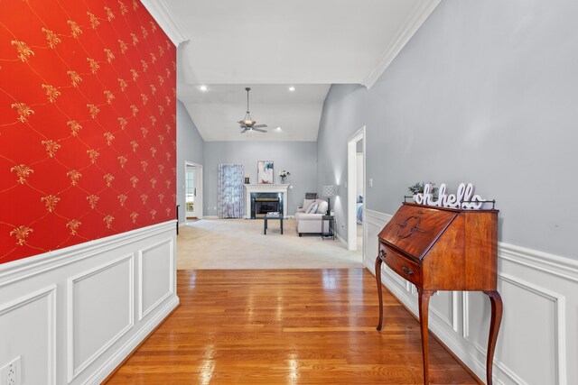 hall with ornamental molding, vaulted ceiling, and hardwood / wood-style floors