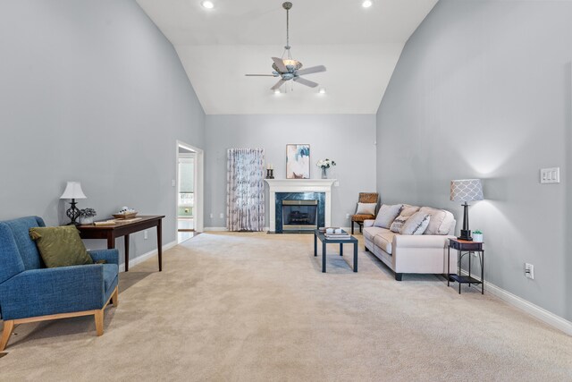 living room with high vaulted ceiling, a premium fireplace, ceiling fan, and light carpet