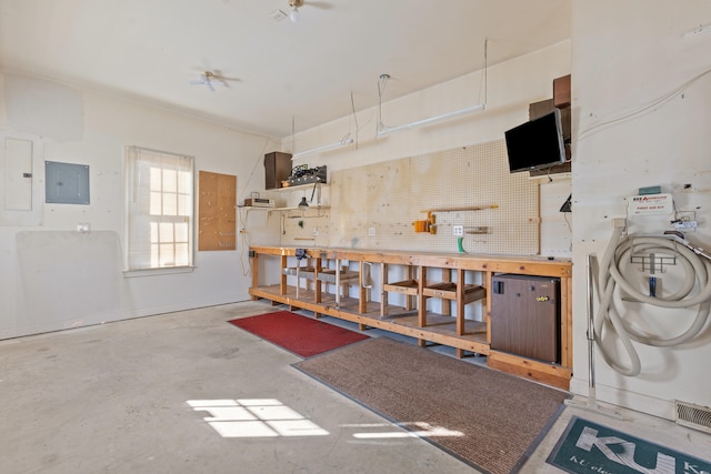 miscellaneous room with electric panel, a workshop area, and concrete floors