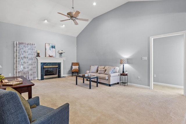 carpeted living room with ceiling fan, a premium fireplace, and high vaulted ceiling