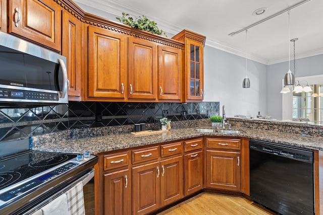 kitchen featuring sink, crown molding, dishwasher, dark stone counters, and light wood-type flooring