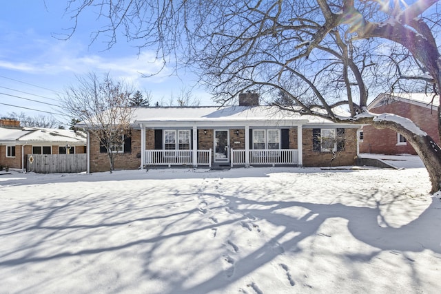 snow covered property with covered porch