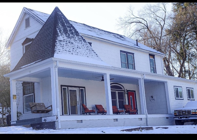 snow covered rear of property featuring a porch