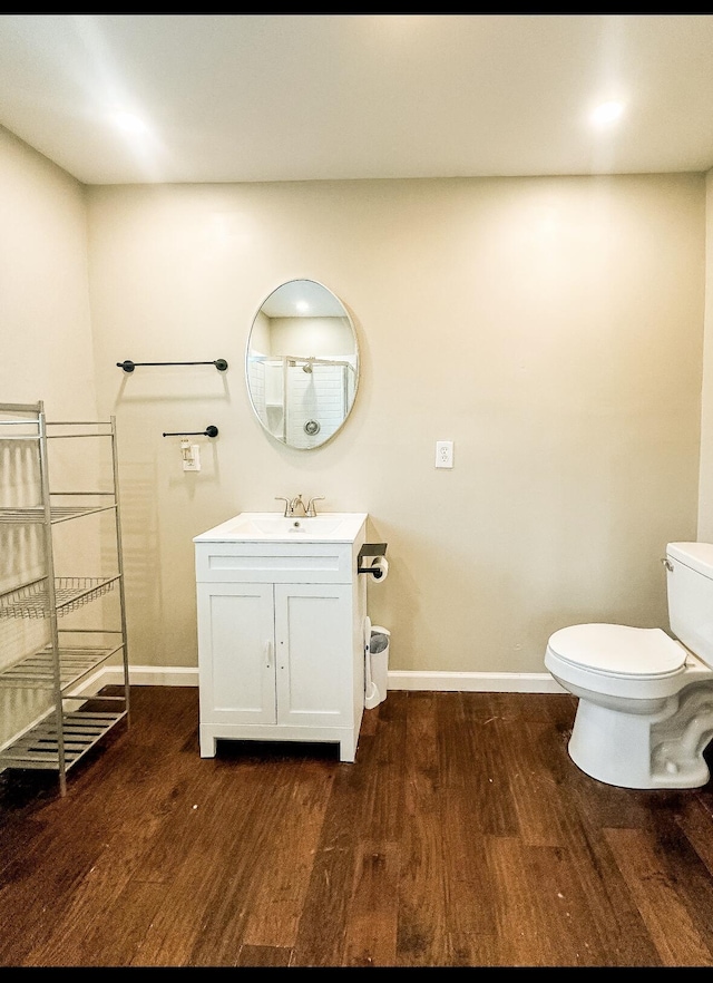 bathroom with vanity, hardwood / wood-style flooring, and toilet