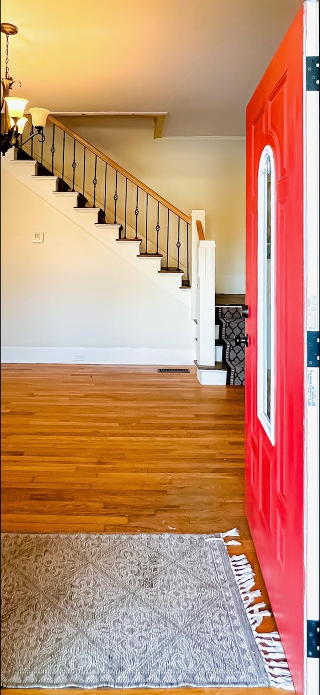 foyer entrance featuring hardwood / wood-style floors and an inviting chandelier