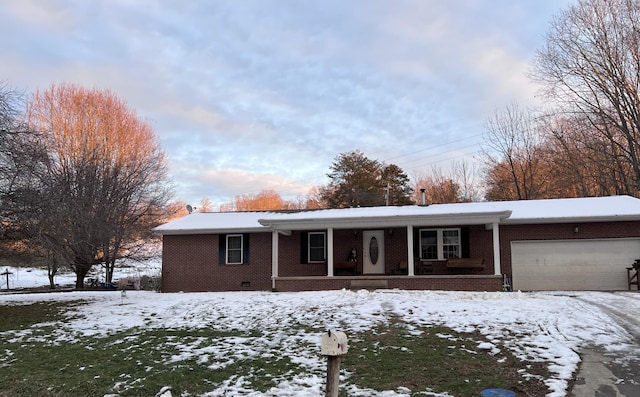 ranch-style house featuring covered porch and a garage